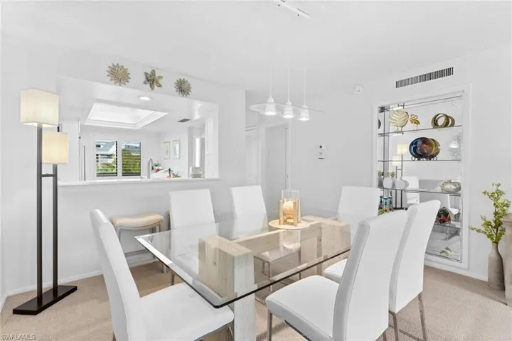 Dining room with light carpet and a tray ceiling