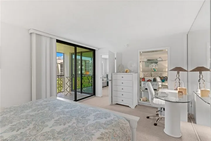 Primary Bedroom featuring light carpet, access to exterior, and expansive windows