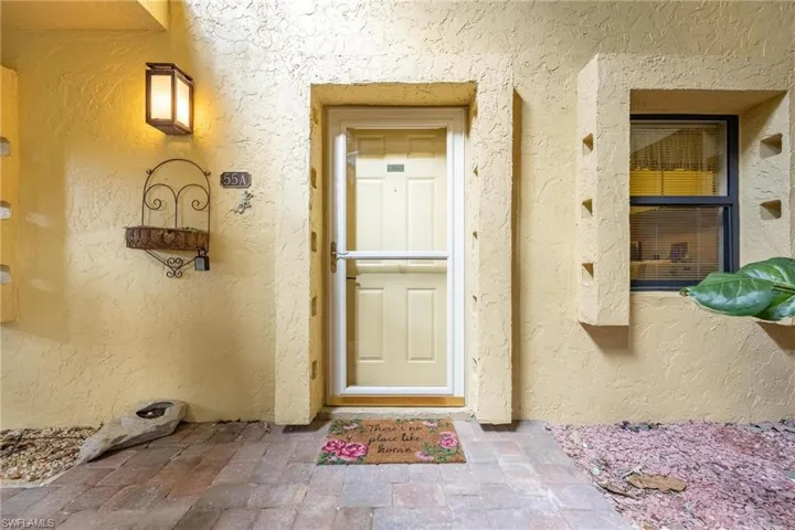 Doorway to property featuring stucco siding