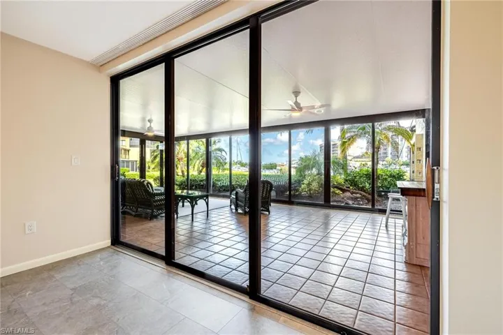 Entryway featuring healthy amount of natural light, a sunroom, floor to ceiling windows, a ceiling fan, and tile patterned floors