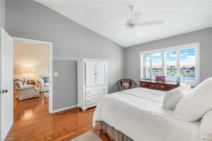 Bedroom featuring ceiling fan, light hardwood / wood-style flooring, and lofted ceiling