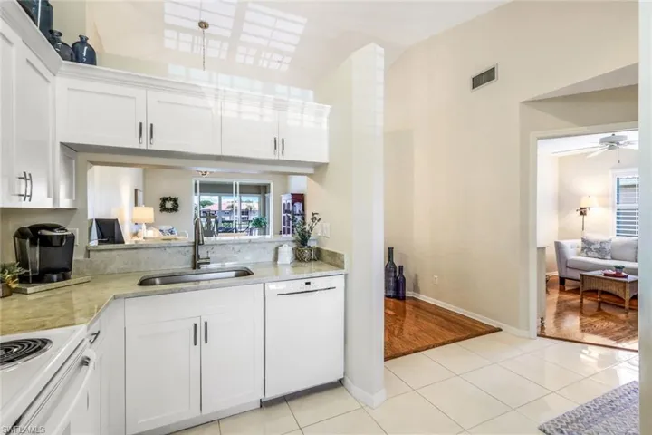 Kitchen featuring white cabinets, white dishwasher, ceiling fan, and light wood-type flooring