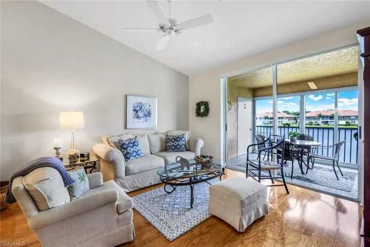 Living room featuring light hardwood / wood-style flooring, ceiling fan, and vaulted ceiling