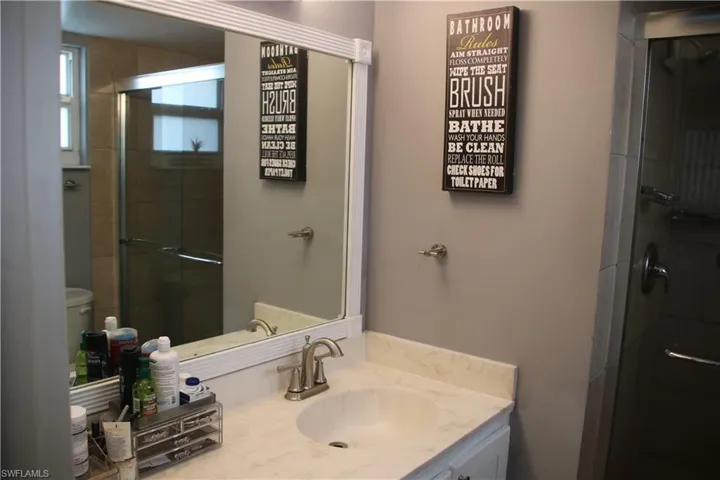Bathroom featuring walk in shower, toilet, and vanity