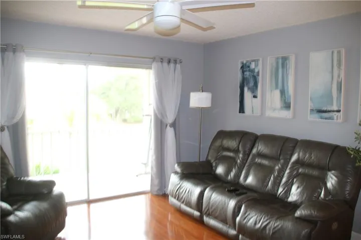 Living room with plenty of natural light, wood-type flooring, and ceiling fan