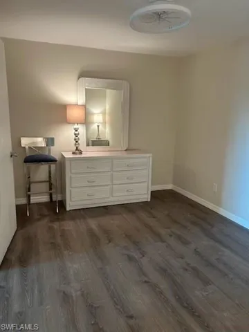 Unfurnished bedroom featuring dark hardwood / wood-style flooring