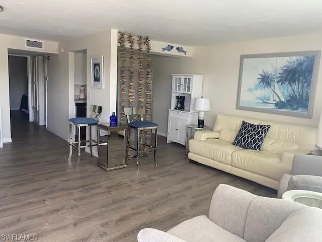 Living room with dark wood-type flooring