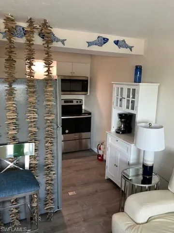 Kitchen featuring dark wood-type flooring and stove