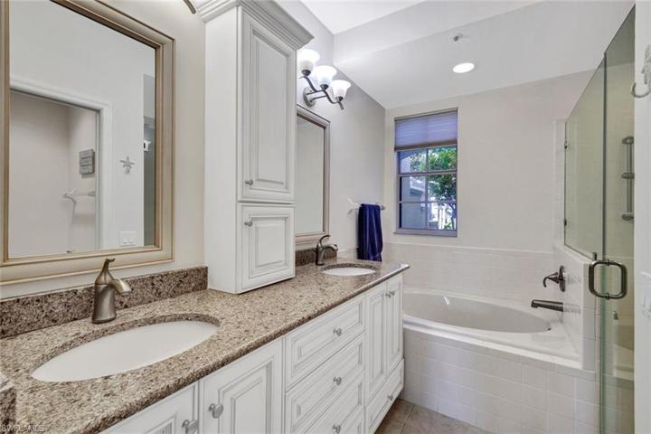 Dual sinks in primary bath with soaking tub and walk in shower.