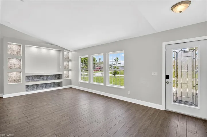 Bright Living Room with Vaulted Ceilings and Beautiful Built-In Shelves