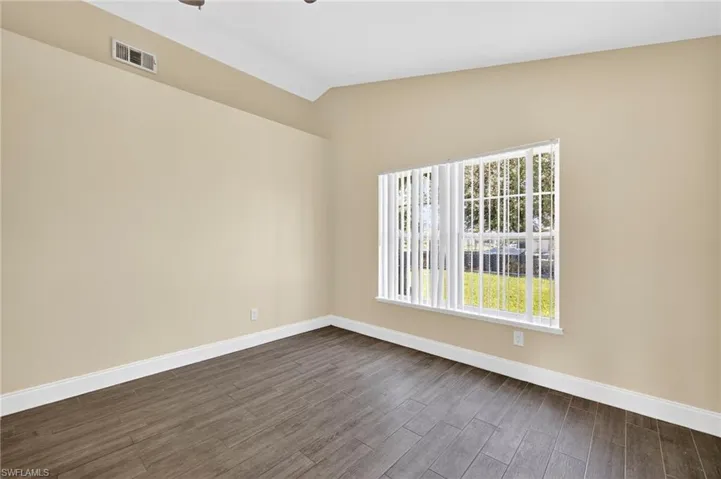 This Bedroom features a large window and faces the backyard