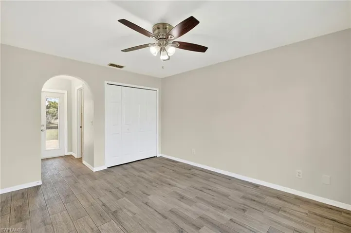 Ceiling Fan and arched entrance leading you to the In-Suite Bathroom