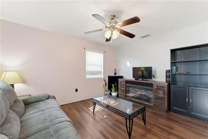 Living area featuring dark wood finished floors and ceiling fan