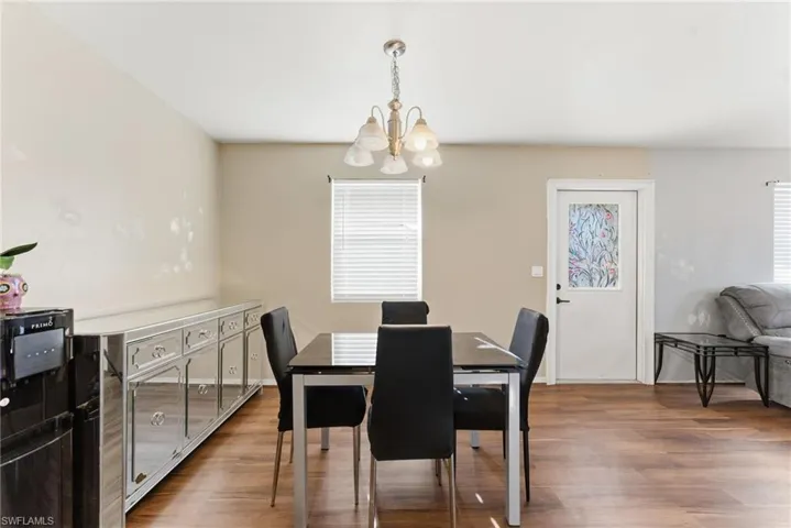 Dining area featuring dark wood-style flooring and a chandelier