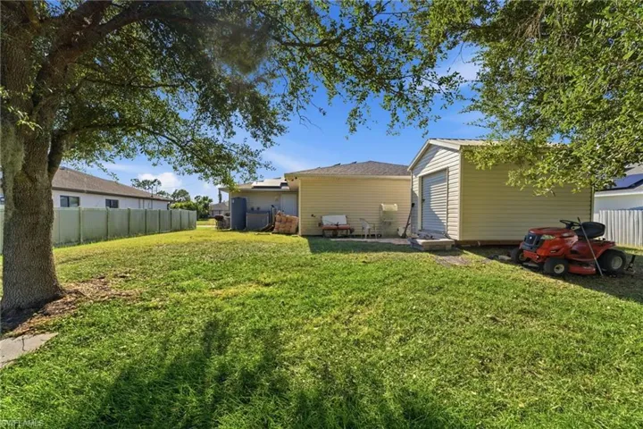 Back of house with a patio area and an outbuilding