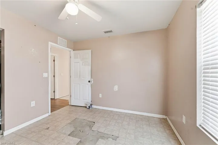 Unfurnished room with light floors and ceiling fan