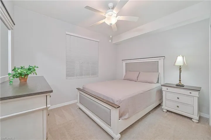 Comfortable guest bedroom featuring a spacious closet, neutral décor, ceiling fan, and convenient access to the guest bathroom.