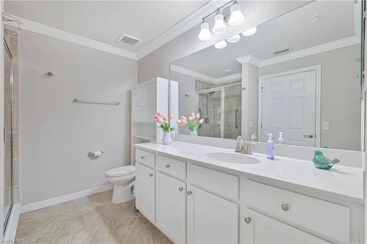 Spacious primary bathroom featuring an oversized dual-sink vanity, walk-in tiled shower, abundant storage, and a bright, open design.
