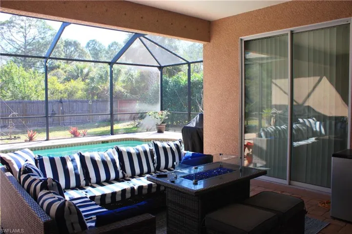 Screened-in patio with concrete flooring, featuring a built-in swimming pool and a sliding glass door entry to the interior