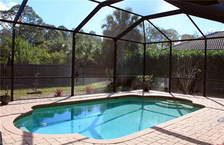 Screened-in outdoor pool featuring a curved design and integrated steps