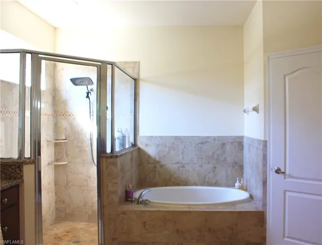 Full tile surround bathtub and walk-in shower with glass enclosure