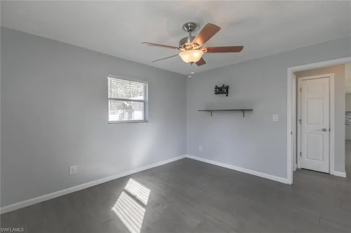 Unfurnished room with ceiling fan, dark hardwood / wood-style floors, and a textured ceiling