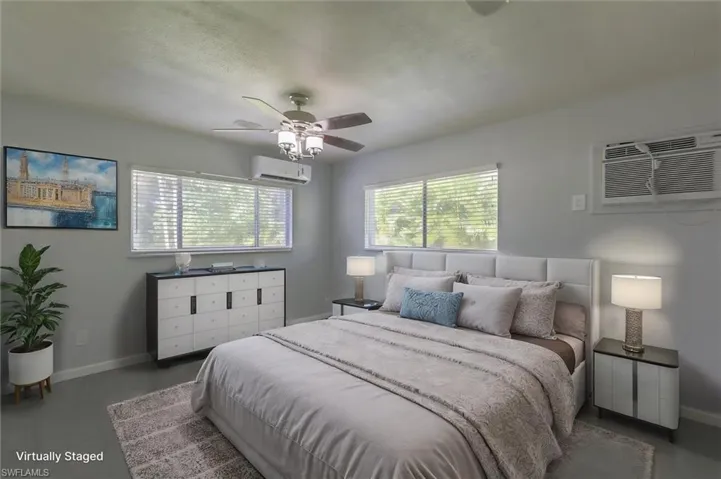 Virtually-staged bedroom featuring ceiling fan and a wall mounted air conditioner
