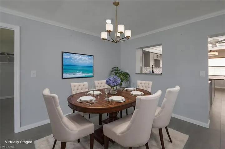 Virtually-staged dining room featuring an inviting chandelier and ornamental molding
