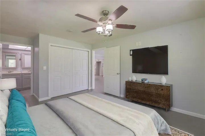 Virtually-staged Bedroom with a closet, ceiling fan, and ensuite bathroom