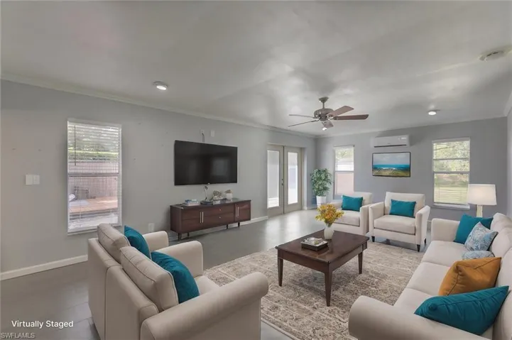 Virtually-staged living room with ceiling fan, crown molding, a healthy amount of sunlight, and light hardwood / wood-style floors