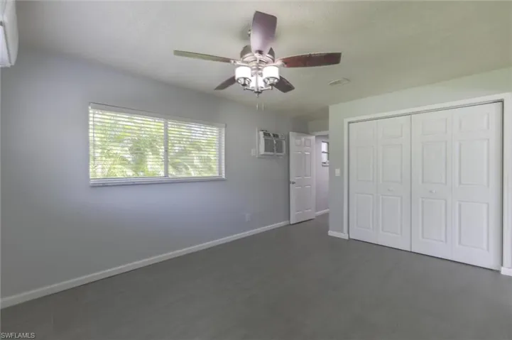 Unfurnished bedroom with ceiling fan and a closet