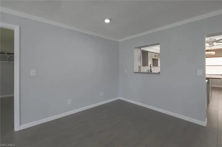 Unfurnished room with dark hardwood / wood-style flooring and ornamental molding