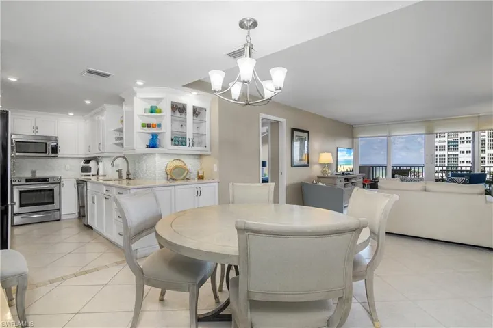Tiled dining area featuring an inviting chandelier and sink