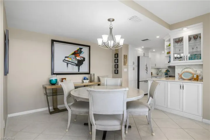Dining area with an inviting chandelier and light tile patterned flooring