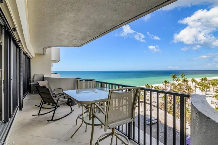 Balcony featuring a water view and a view of the beach