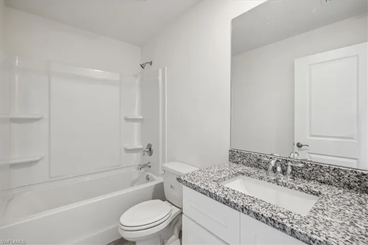 Full bathroom with toilet, shower / washtub combination, and vanity