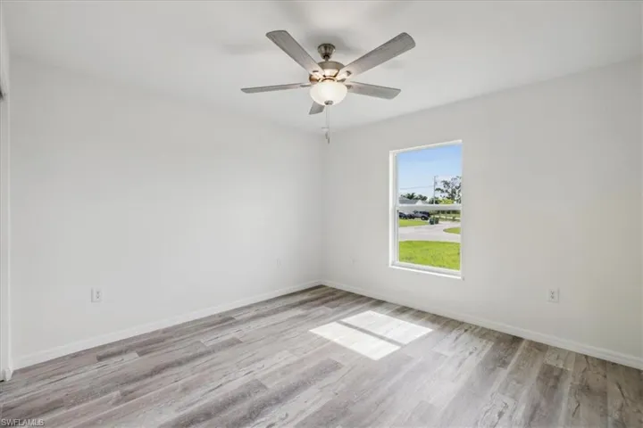Unfurnished room with ceiling fan and light hardwood / wood-style floors