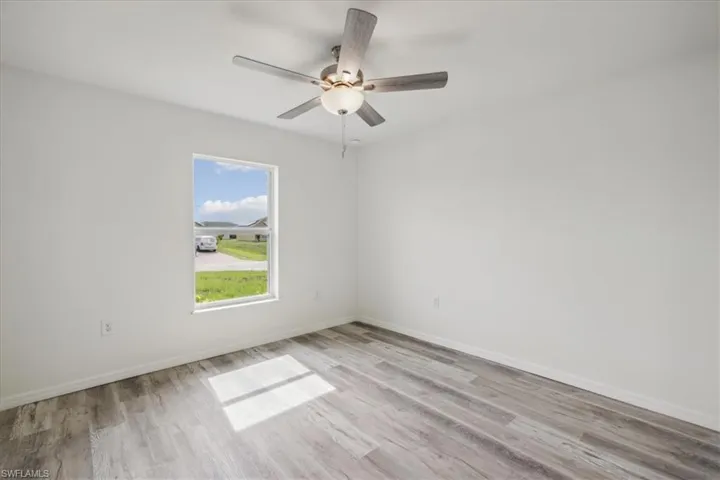 Empty room with wood-type flooring and ceiling fan