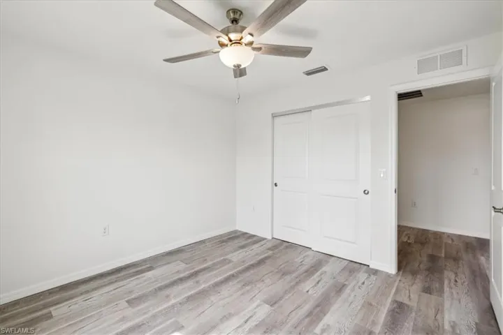 Unfurnished bedroom featuring a closet, ceiling fan, and hardwood / wood-style floors