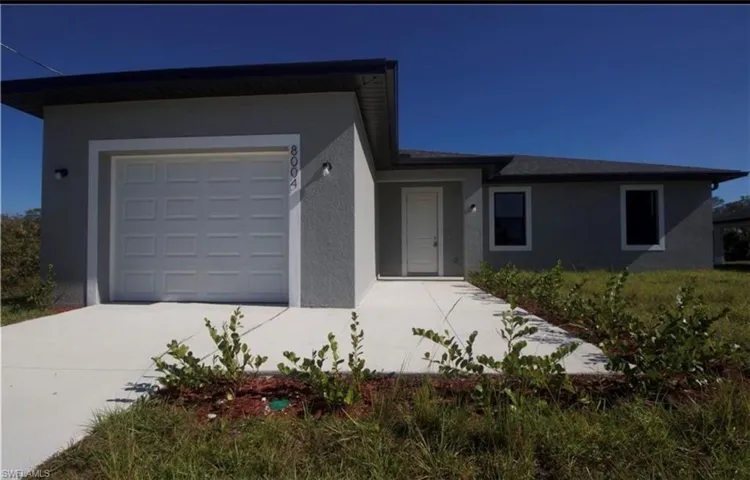Ranch-style home with stucco siding, an attached garage, and concrete driveway