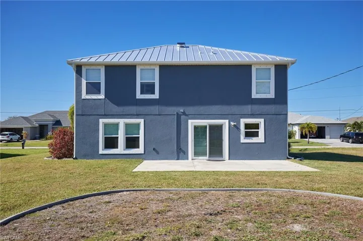 Back of property featuring a patio area and a yard