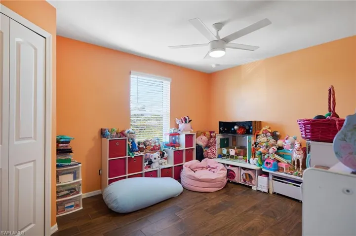 Rec room with dark hardwood / wood-style floors and ceiling fan