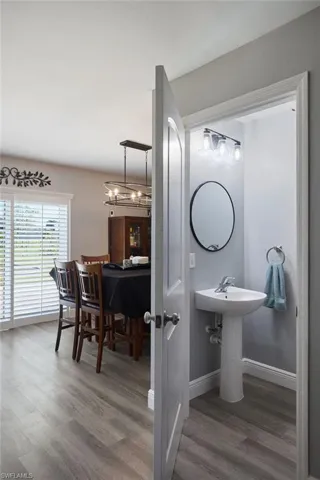 Bathroom with hardwood / wood-style flooring and a notable chandelier