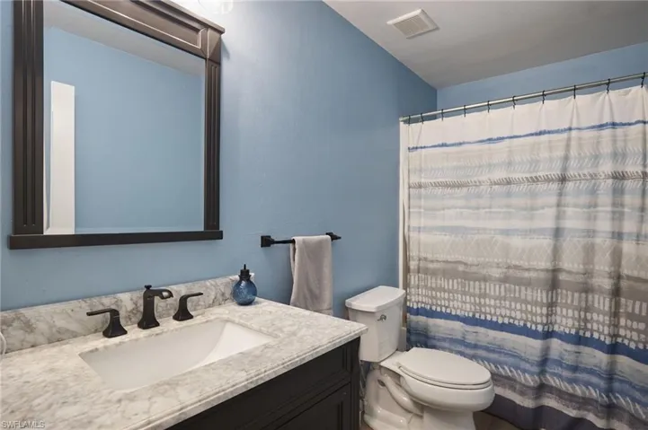 Bathroom featuring vanity, toilet, and walk in shower
