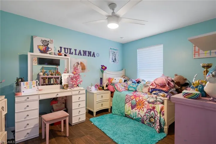 Bedroom featuring ceiling fan and dark wood-type flooring