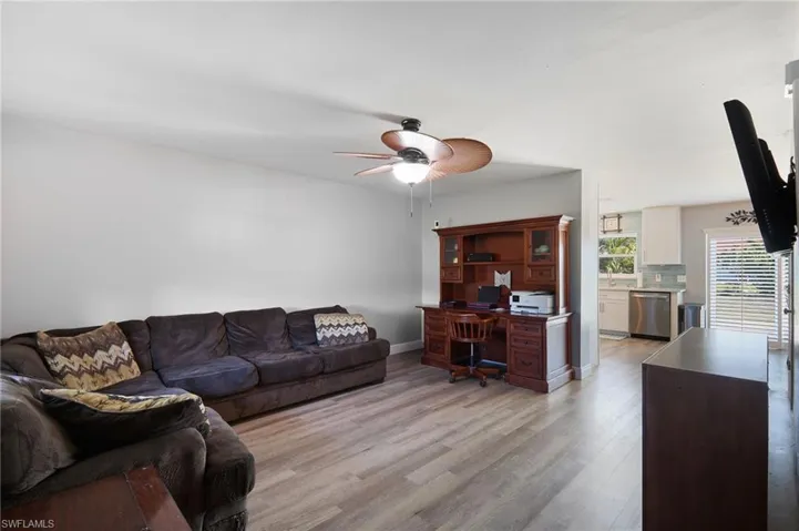 Living room featuring ceiling fan, sink, and light hardwood / wood-style flooring