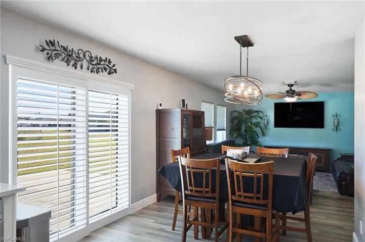 Dining space featuring light hardwood / wood-style floors and ceiling fan with notable chandelier