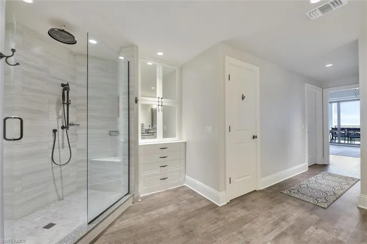 Bathroom with vanity, a stall shower, wood finished floors, and recessed lighting