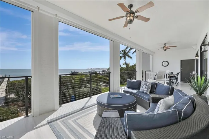 Sunroom / solarium with an outdoor living / dining area, ceiling fan, a water view, and a patio area