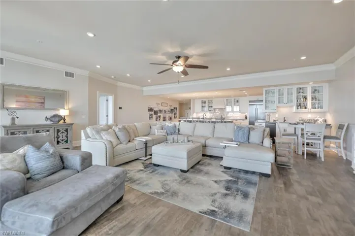 Living room featuring wood finished floors, ceiling fan, recessed lighting, and ornamental molding